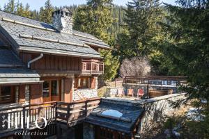 una vista aerea di una casa in legno con balcone di Chalet La Sapinière Méribel les 3 Vallées by HILO Collection - 10 people - Pool table, foosball and PS5 a Les Allues