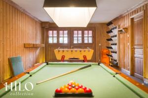 una sala biliardo con tavolo da biliardo e sedia di Chalet La Sapinière Méribel les 3 Vallées by HILO Collection - 10 people - Pool table, foosball and PS5 a Les Allues