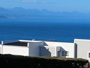 a white building with the ocean in the background at Arrowood 2 in Plettenberg Bay