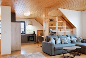 a living room with a blue couch and a kitchen at Wohnung Karin in Spalt +16 photos