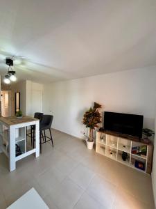 Una sala de estar con un televisor de pantalla plana y una mesa. en NMT House, en Costa Calma