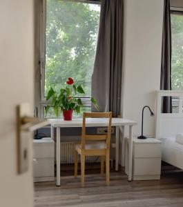 een tafel en stoel in een kamer met een raam bij Sprachcaffe Appartements in Frankfurt am Main