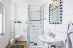 a white bathroom with a sink and a toilet at Tiny Home in Lübeck +47 photos