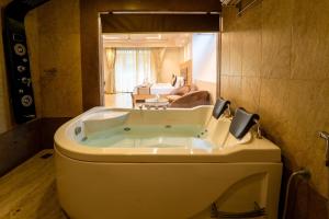 une baignoire dans une salle de bain avec un salon dans l'établissement Grandeur De Sanchi Resort, à Calangute