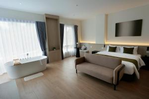 a large hotel room with a bed and a bath tub at Hotel Whitt Hua Hin in Hua Hin +55 photos