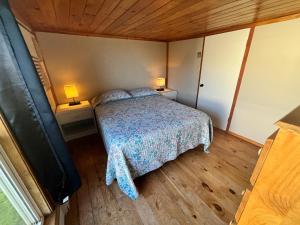 a bedroom with a bed and two lamps on two tables at PEI Cottage Rental in Borden-Carleton
