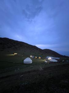 a group of tents in a field at night at Shatyly Camp in Tong