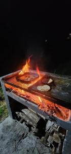 a grill with a pan of food on fire at Green mount in Medellín