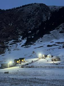 a group of buildings in the snow at night at Shatyly Camp in Tong