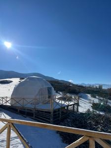 a dome tent in a field with the sun in the sky at Shatyly Camp in Tong