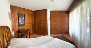 a bedroom with a bed and a wooden door at Charmant appartement, hyper central, à 2 min de tout, énorme terrasse privée et parking couvert in Crans-Montana +14 photos