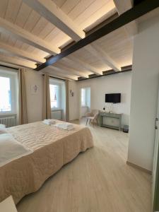una grande camera da letto con un grande letto e una televisione di La Dimora Di Roberta a Montalcino