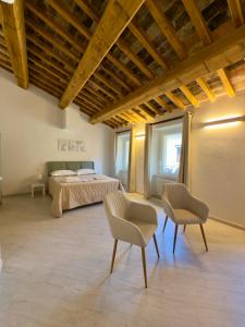 una camera da letto con un letto e due sedie di La Dimora Di Roberta a Montalcino