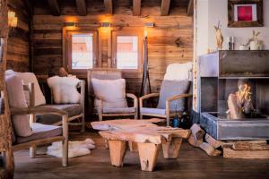 a room with chairs and a table and a fireplace at Le Chalet St Martin 10 pers, 5 chambres, avec sauna, piscine in Saint-Martin-de-Belleville +39 photos