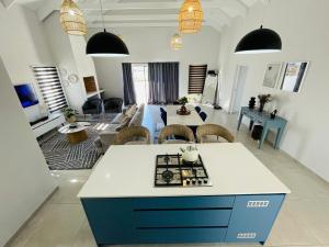 a large living room with a blue and white kitchen at 44 Staycation Beach-house in Britannia Bay