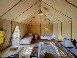a room with three beds in a tent at Agafay, La Ferme Nomade Bivouac in El Karia