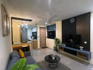 a living room with a couch and a television at Seaview Jacuzzi Starry - 5 pax in Malacca