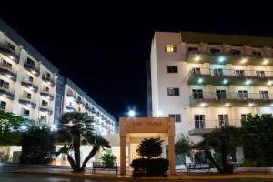 un hôtel la nuit avec un panneau devant lui dans l'établissement Topaz Hotel, à San Pawl il-Baħar