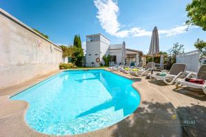 a swimming pool with chaise lounge chairs and a swimming pool at Casa Luna a 700m de la playa en puerto Alcudia in Port d'Alcudia