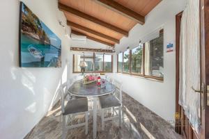 a dining room with a glass table and chairs at Casa Luna a 700m de la playa en puerto Alcudia in Port d'Alcudia