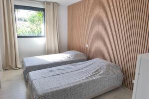 two beds in a small room with a window at Apartment 3 rooms with garden in Ajaccio in Ajaccio +6 photos
