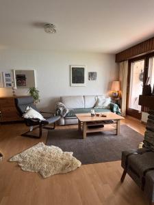 a living room with a couch and a coffee table at Charmant appartement, hyper central, à 2 min de tout, énorme terrasse privée et parking couvert in Crans-Montana