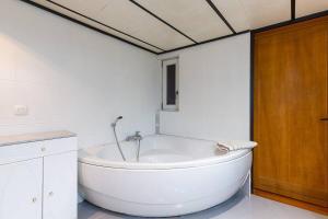 a white bathroom with a large tub in it at Maison alsacienne 2-5 pers au centre d'Obernai in Obernai +20 photos