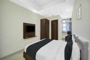 a bedroom with a bed and a tv on the wall at HOTEL O HAPPY PLACE HOTEL & RESORT in Gaya