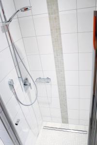 eine Dusche im Bad mit weißen Fliesen in der Unterkunft Hoofer Apartments in Schauenburg