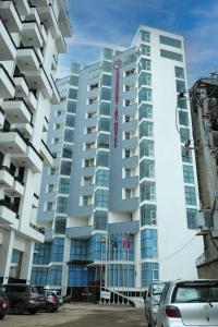 Un edificio alto con coches aparcados delante. en Crescent International Hotel, en Addis Ababa