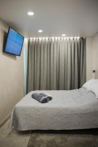 a bedroom with a bed with a television on the wall at Sucro Playa Apartment in Cullera
