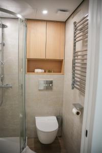 a bathroom with a toilet and a glass shower at Sucro Playa Apartment in Cullera