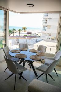 a table and chairs in a room with a large window at Sucro Playa Apartment in Cullera