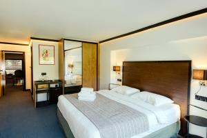 a hotel room with a large bed and a mirror at ANDROMEDA PARK Suites in Athens