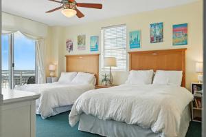 two beds in a bedroom with a window at *New Listing* Breathtaking 2BR condo with 2 Private Oceanview Balconys at Wyndham Ocean Walk Resort in Daytona Beach +53 photos