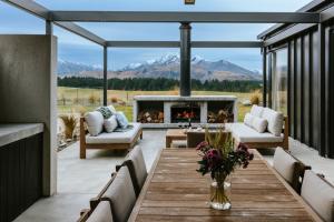 a patio with a table and a fireplace at Riverslea in Wanaka