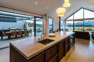 a kitchen with a sink and a table and a dining room at Riverslea in Wanaka