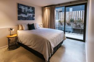 a bedroom with a bed and a large window at Riverslea in Wanaka +18 photos