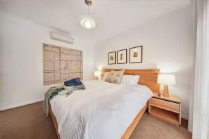 a bedroom with a large white bed and two lamps at Serenity on Sunningdale in Torquay