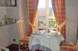 a table in a room with a window at Logis Hôtel & Restaurant - Le Bretagne in Sillé-le-Guillaume