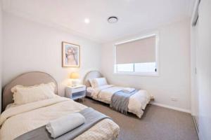 a bedroom with two beds and a window at Macintyre House in Dubbo
