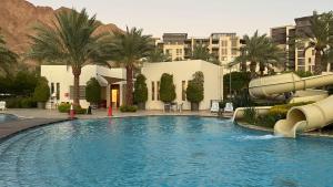 a swimming pool with a water slide in a resort at Flow - Al Raha Village in Aqaba