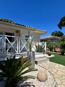 a house with a white fence and a garden at Jolie Maison Cosy Vue Golfe de Saint Tropez in Gassin
