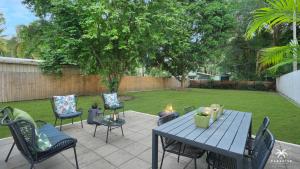 a patio with a table and chairs and a fire place at The Arlington Beachfront House in Clifton Beach