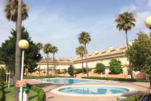 a building with a swimming pool and palm trees at Valencia Flat Rental Perellonet in Valencia