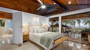 a bedroom with a bed and a balcony at The Arlington Beachfront House in Clifton Beach