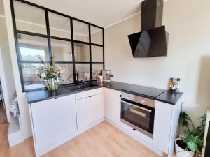 Una cocina con gabinetes blancos y una encimera negra. en Modern apartment in the heart of Drammen, en Drammen 12 fotos más