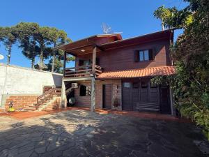 a house with a porch and a garage at Sua Casa no Centro Gramado, 1km Rua Coberta in Gramado