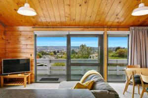 a living room with a couch and a tv at Modern Townhouse, Stunning Views in Taupo