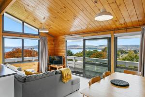 a living room with a couch and a table at Modern Townhouse, Stunning Views in Taupo